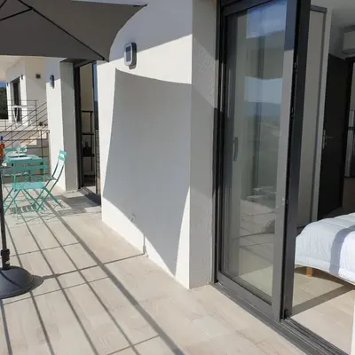 a room with sliding glass doors on a patio at Villa L'Arbousier 4 pers piscine chauffée 2 min plage en voiture in Sainte-Lucie de Porto-Vecchio
