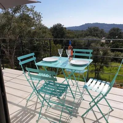 a blue table and two chairs on a deck at Villa L'Arbousier 4 pers piscine chauffée 2 min plage en voiture in Sainte-Lucie de Porto-Vecchio