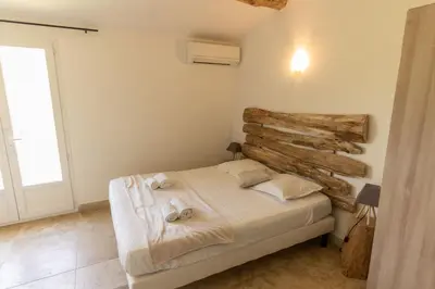 a bedroom with a bed and a wooden wall at A Machja in Olmiccia