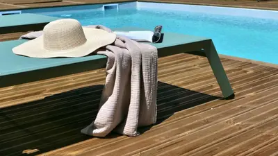 a hat and towels on a table next to a pool at A Machja in Olmiccia