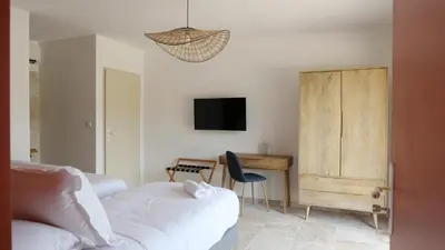 a bedroom with a bed and a desk and a tv at A Machja in Olmiccia