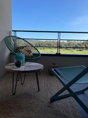 a chair and a table in a room with a window at CASA STANATURA in Porto-Vecchio