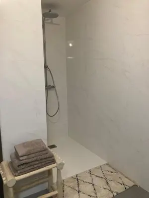a shower in a bathroom with a stool and towels at CASA STANATURA in Porto-Vecchio