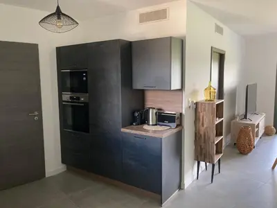 a kitchen with black cabinets and a microwave at CASA STANATURA in Porto-Vecchio
