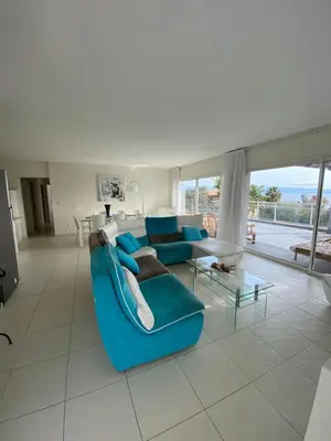 a living room with a blue couch and a table at Le Loft in Ajaccio