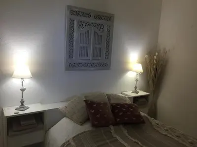 a bedroom with a bed with two lamps on it at Favone Mini Villa Playa del Oro in Favone