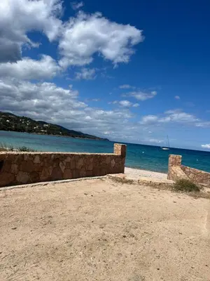 a stone wall on the beach near the ocean at Favone Mini Villa Playa del Oro in Favone
