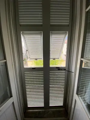 a window with blinds on a door in a house at Charmant T1 plein centre Corte au 13 cours paoli wifi gratuit calme lumineux in Corte