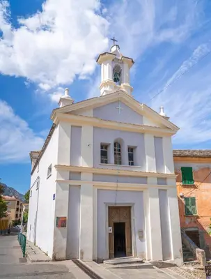a white church with a tower on top of it at Charmant T1 plein centre Corte au 13 cours paoli wifi gratuit calme lumineux in Corte