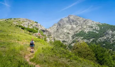 a person walking on a trail in the mountains at Charmant T1 plein centre Corte au 13 cours paoli wifi gratuit calme lumineux in Corte