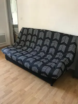 a black and white couch sitting in a room at Charmant T1 plein centre Corte au 13 cours paoli wifi gratuit calme lumineux in Corte