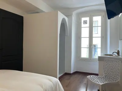 a bedroom with a bed and a sink and a window at Charmant T2 au coeur de la rue Fesch in Ajaccio