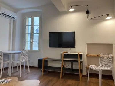 a living room with a flat screen tv on a wall at Charmant T2 au coeur de la rue Fesch in Ajaccio