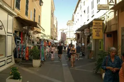 a group of people walking down a street with shops at Charmant T2 au coeur de la rue Fesch in Ajaccio