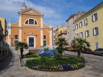 a building in a city with palm trees in front of it at Charmant T2 au coeur de la rue Fesch in Ajaccio
