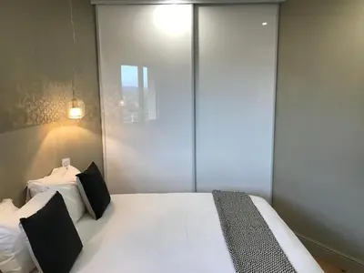 a bedroom with a large white bed with black pillows at Appartements de Standing - Panate in Corte