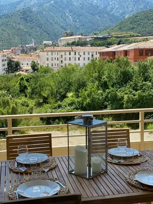 a table with plates of food on top of a balcony at Appartements de Standing - Panate in Corte