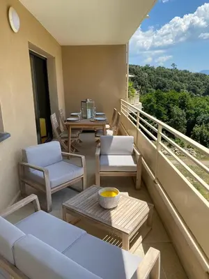 a balcony with chairs and a table on a balcony at Appartements de Standing - Panate in Corte