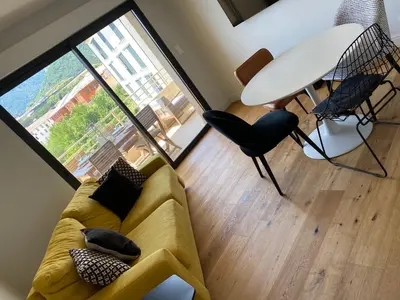 a living room with a yellow couch and a large window at Appartements de Standing - Panate in Corte