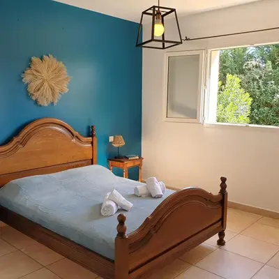 a bedroom with a bed with blue walls and a window at Villa Ribba 6 pers piscine 5 min plage en voiture in Gialla