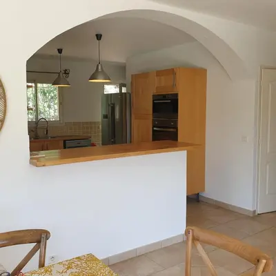 a kitchen with a counter and an archway at Villa Ribba 6 pers piscine 5 min plage en voiture in Gialla