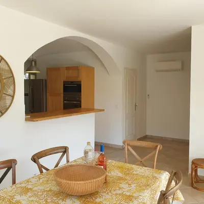 a dining room with a table and a kitchen at Villa Ribba 6 pers piscine 5 min plage en voiture in Gialla