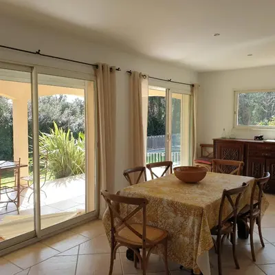 a dining room with a table and chairs and a sliding glass door at Villa Ribba 6 pers piscine 5 min plage en voiture in Gialla