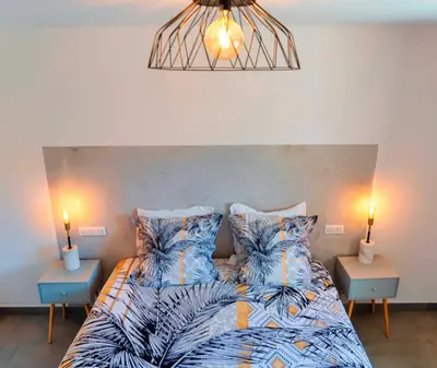 a bedroom with a bed with two night stands and two lamps at Solaneos propose magnifique T4 neuf sur le port avec Piscine CHAUFFEE in Porto-Vecchio