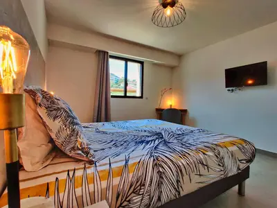 a bedroom with a bed with a zebra patterned blanket at Solaneos propose magnifique T4 neuf sur le port avec Piscine CHAUFFEE in Porto-Vecchio
