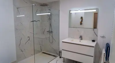 a bathroom with a glass shower and a sink at Solaneos propose magnifique T4 neuf sur le port avec Piscine CHAUFFEE in Porto-Vecchio