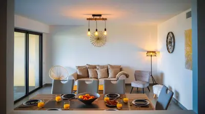 a living room with a table and a couch at Solaneos propose magnifique T4 neuf sur le port avec Piscine CHAUFFEE in Porto-Vecchio