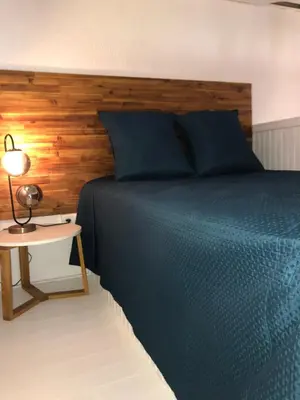 a bedroom with a blue bed and a lamp on a table at Joli studio maisonnette à 100m de la plage in Porticcio