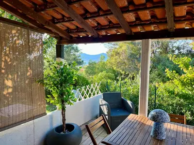 a porch with a table and a potted plant at Joli studio maisonnette à 100m de la plage in Porticcio
