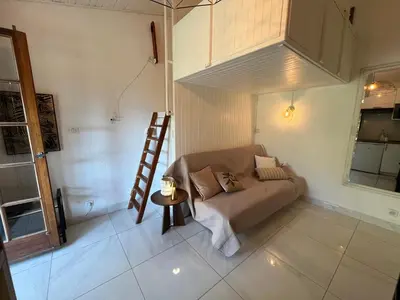 a living room with a couch and a ladder at Joli studio maisonnette à 100m de la plage in Porticcio