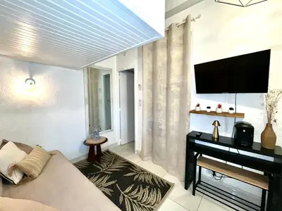 a living room with a couch and a flat screen tv at Joli studio maisonnette à 100m de la plage in Porticcio