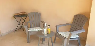 two chairs and a table with two bottles of wine at Villa Ribba 10 pers piscine 5 min plage en voiture in Porto-Vecchio