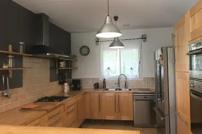 a kitchen with wooden cabinets and a sink and a window at Villa Ribba 10 pers piscine 5 min plage en voiture in Porto-Vecchio