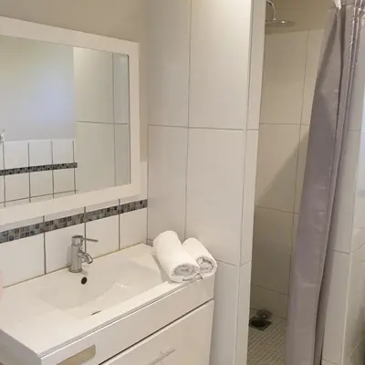 a white bathroom with a sink and a mirror at Villa Ribba 10 pers piscine 5 min plage en voiture in Porto-Vecchio