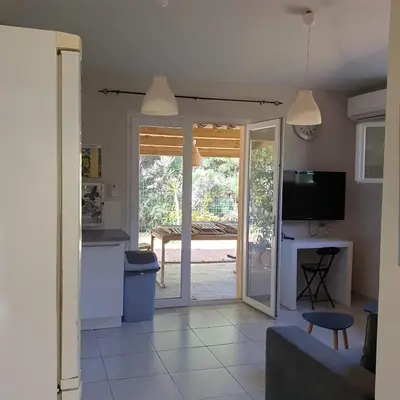 a kitchen and living room with a sliding glass door at Villa Ribba 10 pers piscine 5 min plage en voiture in Porto-Vecchio