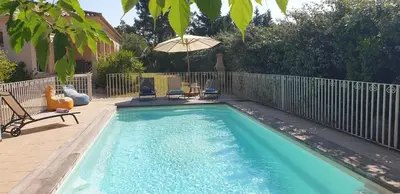 a swimming pool with two chairs and an umbrella at Villa Ribba 10 pers piscine 5 min plage en voiture in Porto-Vecchio