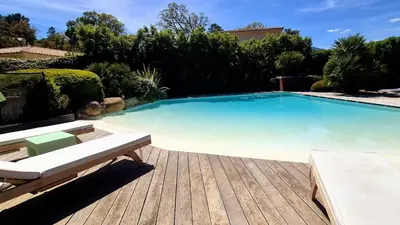 a large swimming pool sitting on a wooden deck at Villa Lucendiluna 14 personnes piscine plage 5min le paradis in Sainte-Lucie de Porto-Vecchio
