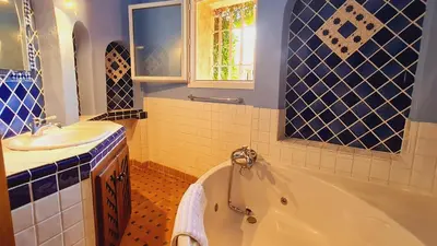 a blue and white bathroom with a tub and a sink at Villa Lucendiluna 14 personnes piscine plage 5min le paradis in Sainte-Lucie de Porto-Vecchio