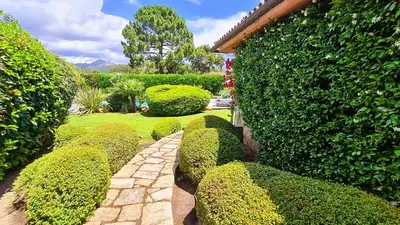 a garden with green bushes and a walk way at Villa Lucendiluna 14 personnes piscine plage 5min le paradis in Sainte-Lucie de Porto-Vecchio