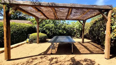 a picnic table under a wooden pergola at Villa Lucendiluna 14 personnes piscine plage 5min le paradis in Sainte-Lucie de Porto-Vecchio