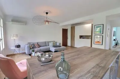 a living room with a table with a glass bottle on it at Charmant T2 avec balcon - Parking, AC, Wifi in Ajaccio