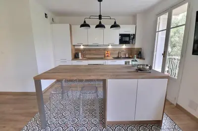a kitchen with a wooden counter top in a room at Charmant T2 avec balcon - Parking, AC, Wifi in Ajaccio
