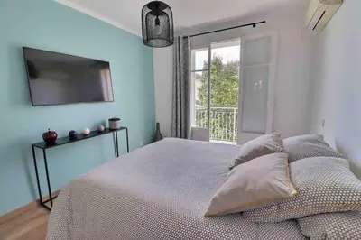 a bedroom with a bed with a television and a window at Charmant T2 avec balcon - Parking, AC, Wifi in Ajaccio