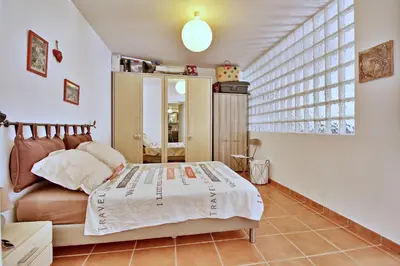 a bedroom with a bed and a large window at Appartement T2 Prunello By Intendance Excellency in Porto-Vecchio