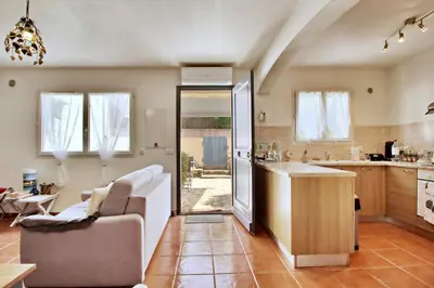 a living room with a couch and a kitchen at Appartement T2 Prunello By Intendance Excellency in Porto-Vecchio