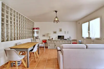 a kitchen and living room with a table and a couch at Appartement T2 Prunello By Intendance Excellency in Porto-Vecchio